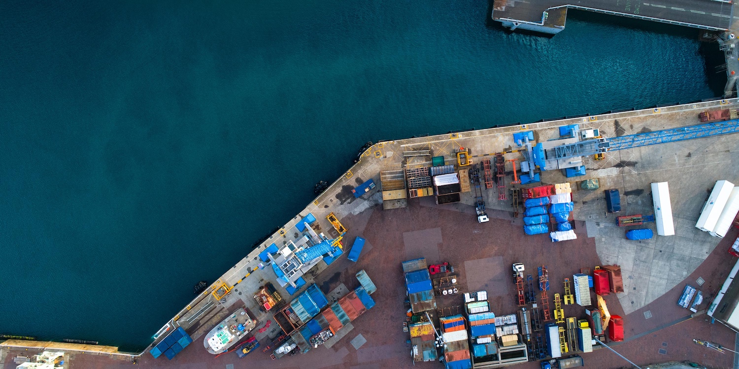 Aerial view of water and dock covered in shipping containers