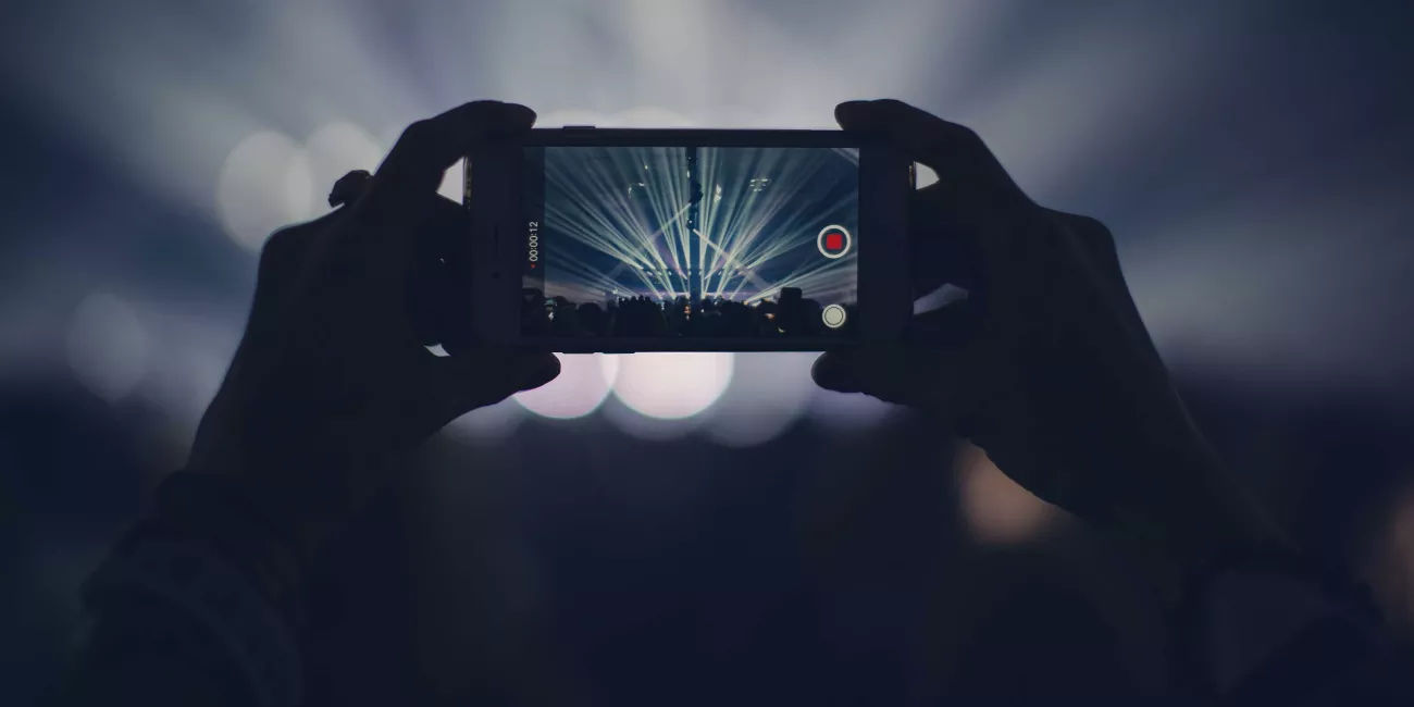 Person recording concert on phone